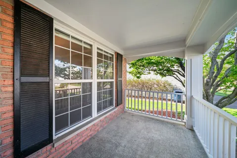 a view of a porch with a floor to ceiling window and wooden fence