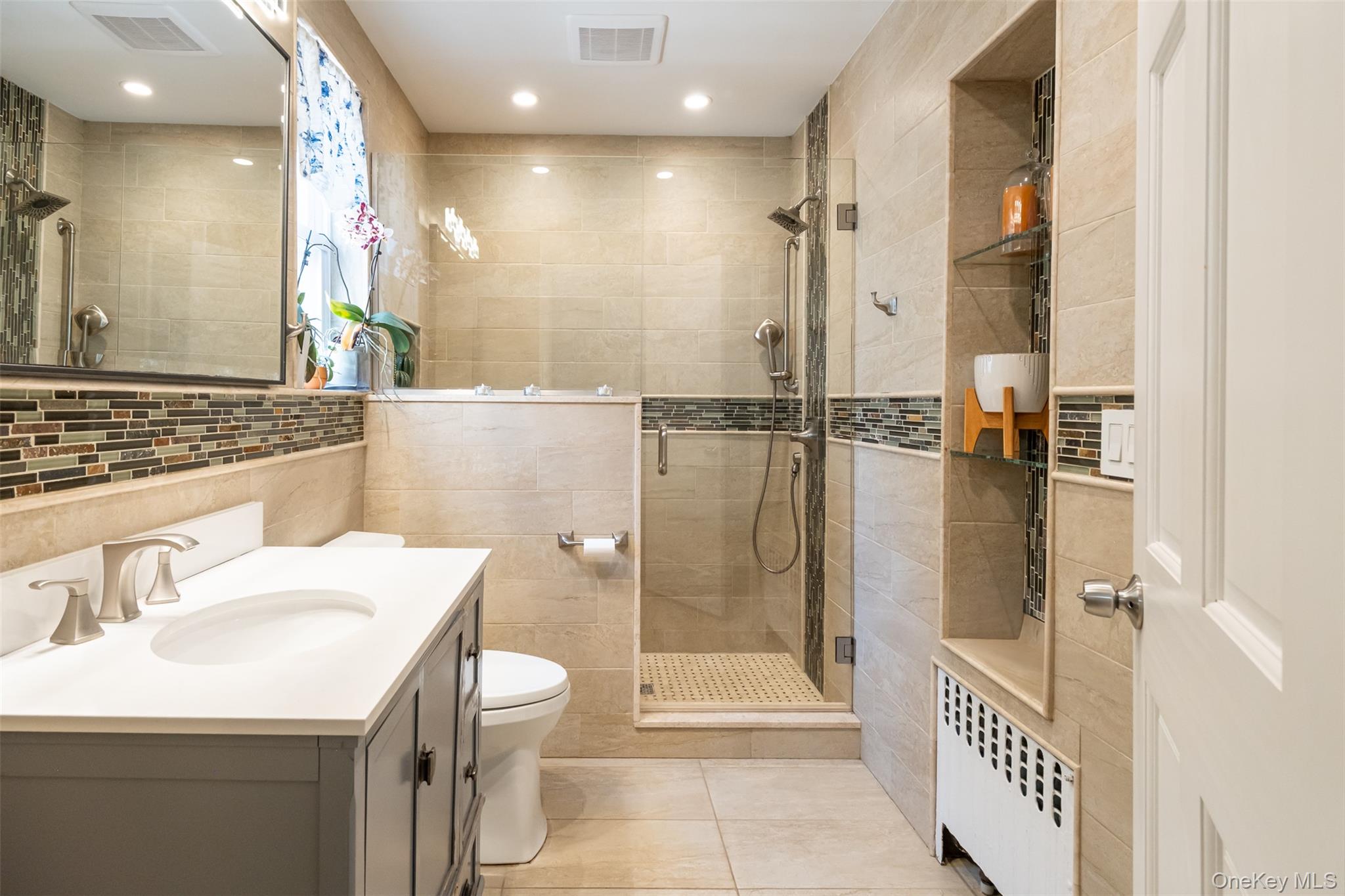 982 Split Rock Road Pelham, NY 10803 - Photo 14 of 33 a bathroom with a sink a toilet a mirror and shower