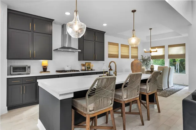 a kitchen with a dining table chairs and white cabinets