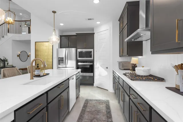 a kitchen with stainless steel appliances kitchen island granite countertop a sink stove and cabinets