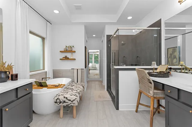 a spacious bathroom with a tub a sink and mirror
