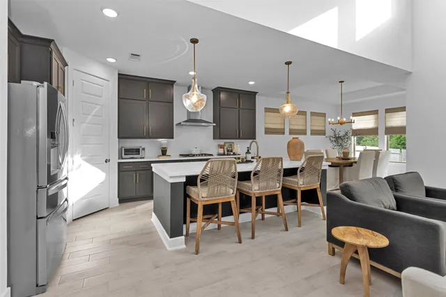 a large kitchen with a table chairs refrigerator and a sink