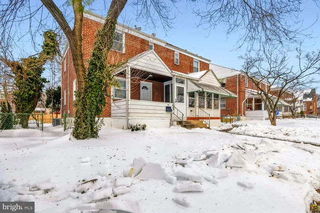 a front view of a house with a yard covered in snow