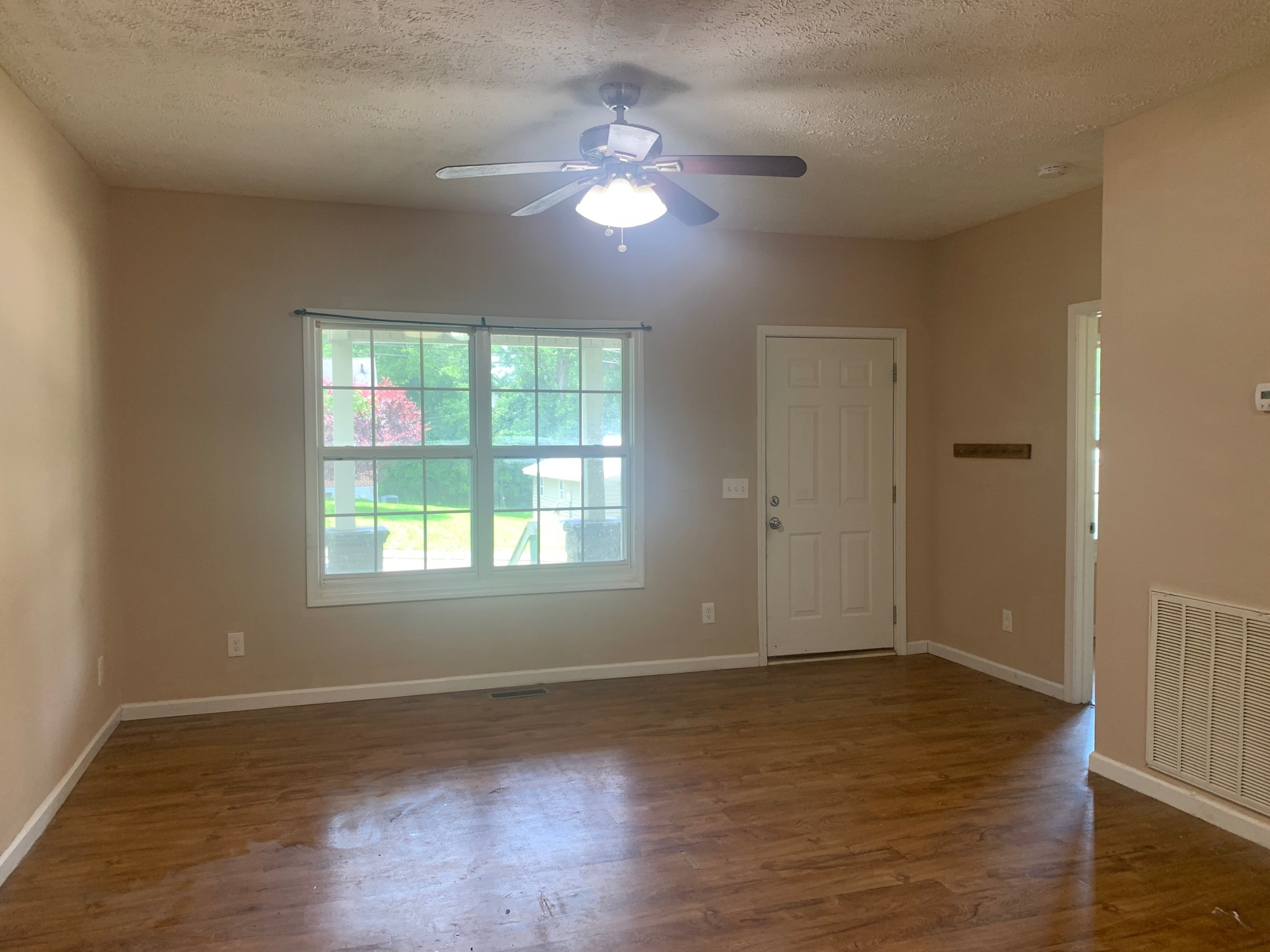 605 South Spring Street Manchester, TN 37355 - Photo 3 of 6 an empty room with wooden floor and windows