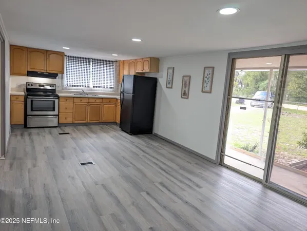 a kitchen with stainless steel appliances a refrigerator and wooden floor