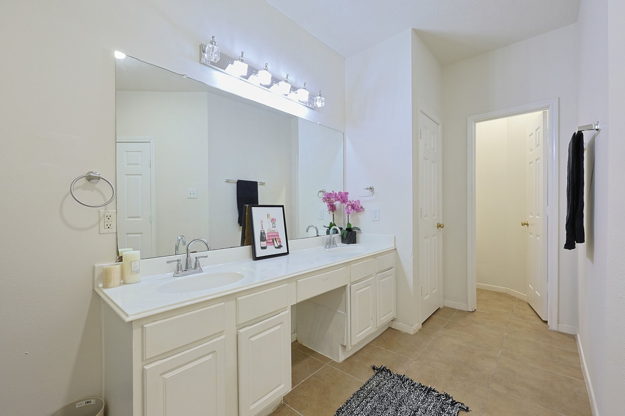 23019 Eastgate Village Drive Spring, TX 77373 - Photo 24 of 46 Bright and spacious bathroom featuring a large mirror, dual sinks, and ample counter space. The neutral tones and modern lighting create a fresh, clean ambiance.