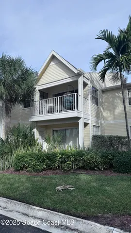 a view of a house with a yard and potted plants