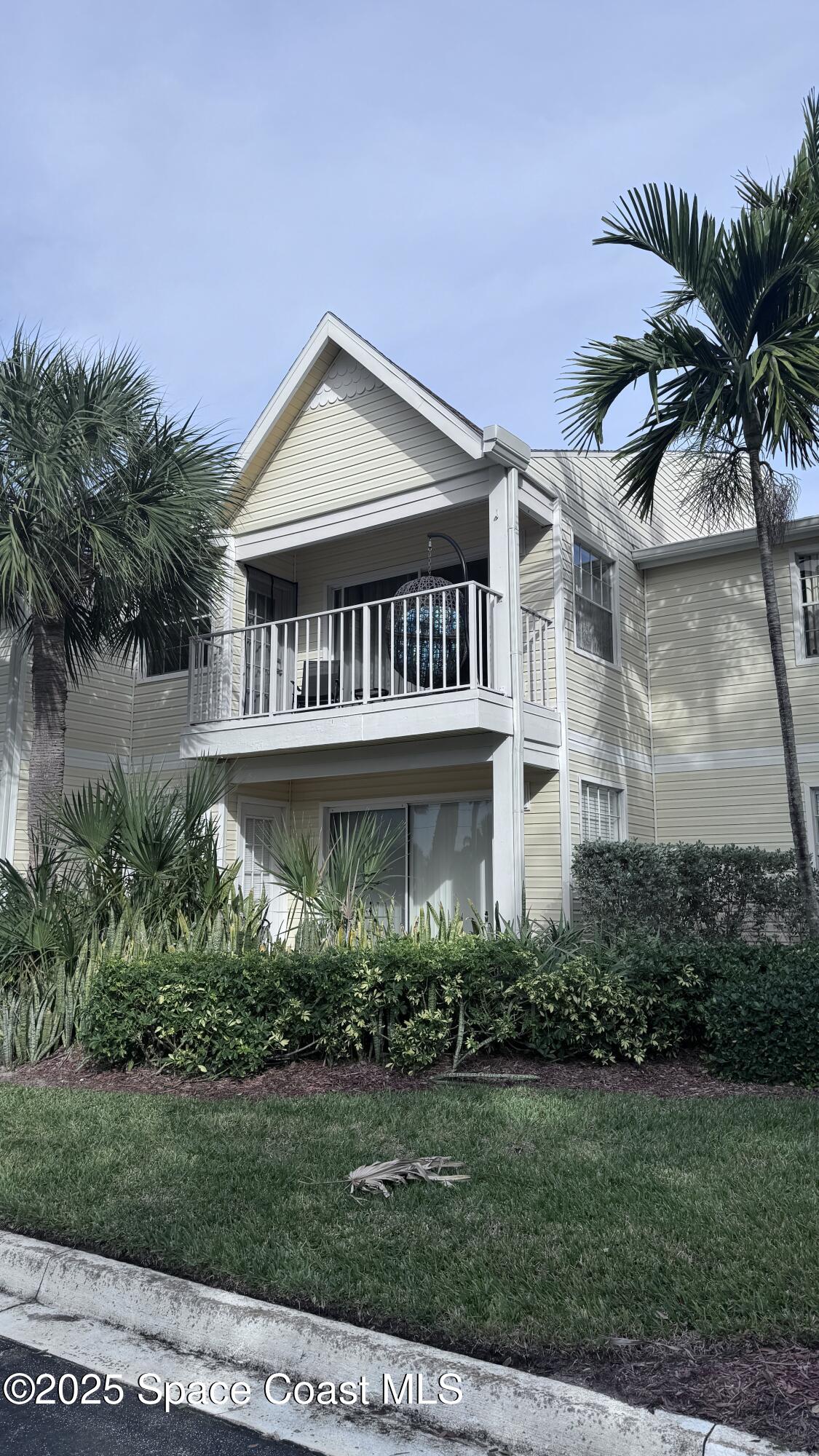 a view of a house with a yard and potted plants