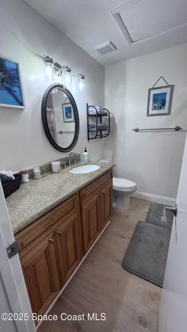 a bathroom with a granite countertop toilet a sink and a mirror