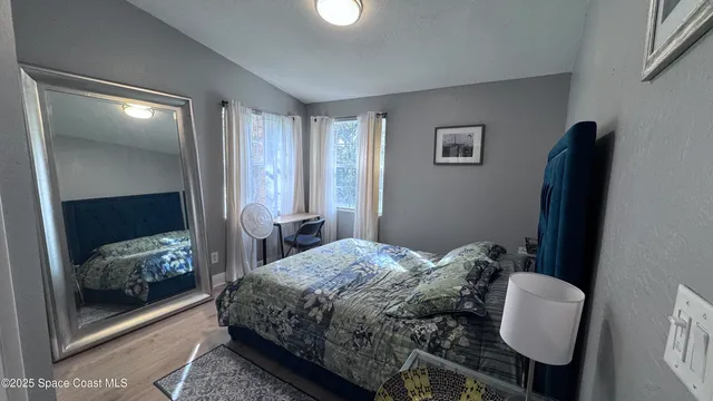 a bedroom with a bed and a mirror on dresser