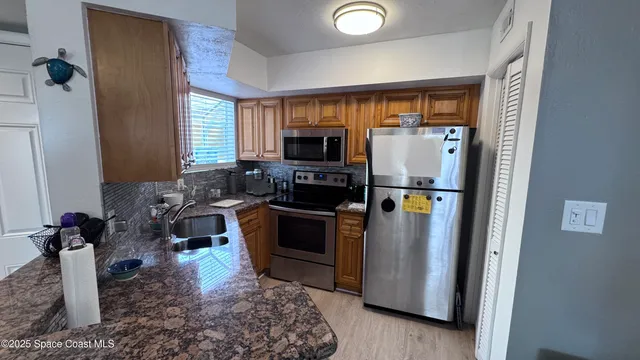 a kitchen with stainless steel appliances granite countertop a refrigerator stove and microwave