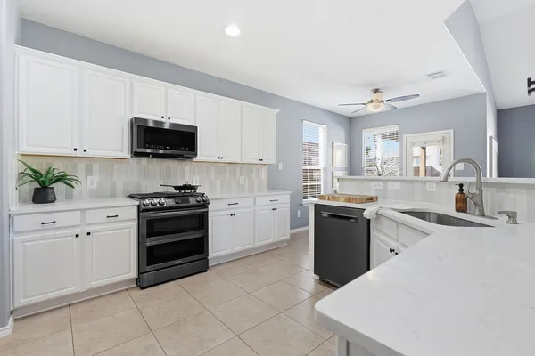 a kitchen with stainless steel appliances a stove sink microwave and cabinets