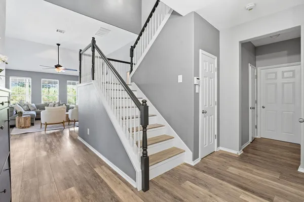 a view of a livingroom with wooden floor and stairs