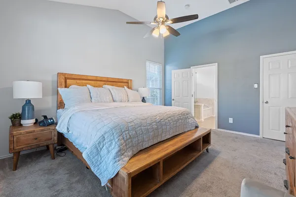 a bed sitting in a bedroom and a chandelier