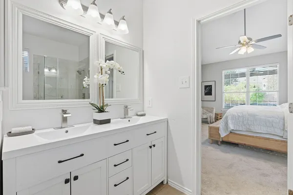 a en suite bathroom with a double vanity sink mirror and window