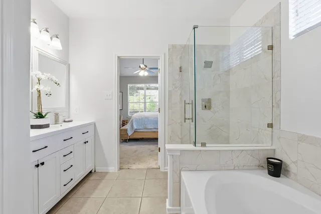 a spacious bathroom with a tub shower and mirror