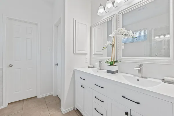 a bathroom with a double vanity sink mirror and