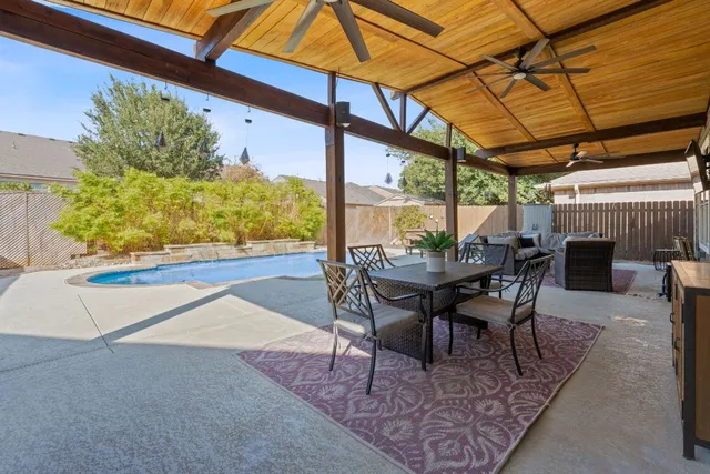 a view of a patio with a table and chairs under an umbrella