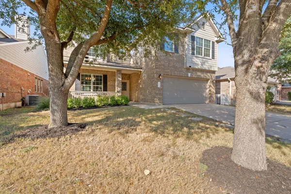 a view of a house with a tree in the yard