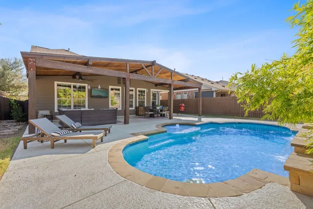 a view of a house with pool and chairs