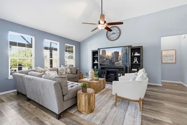 a living room with furniture a flat screen tv and a window