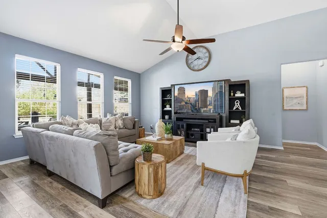 a living room with furniture a flat screen tv and a window