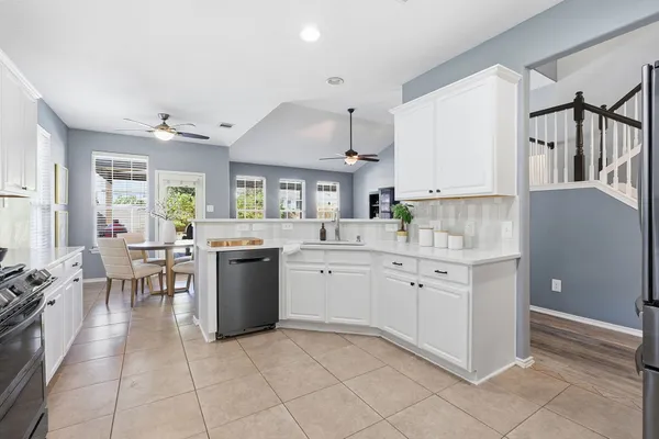 a kitchen with cabinets and chairs
