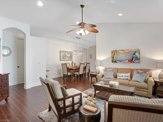 a living room with furniture a dining table and a chandelier