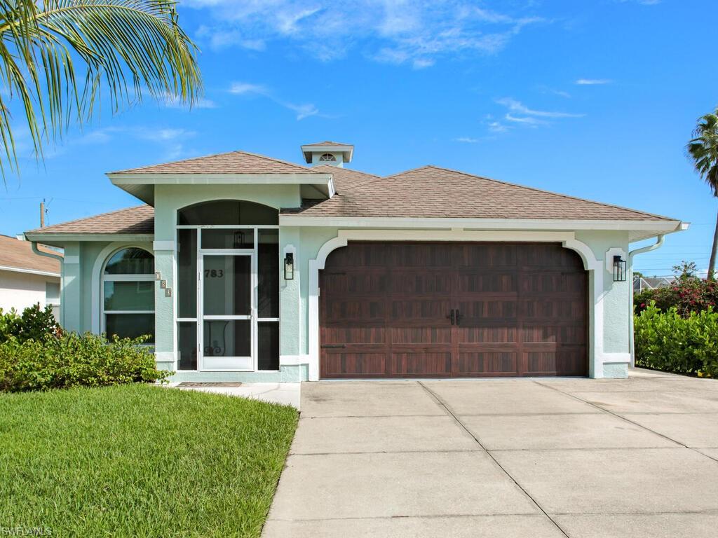 783 92nd Avenue North Naples, FL 34108 - Photo 2 of 32 a front view of a house with a garage