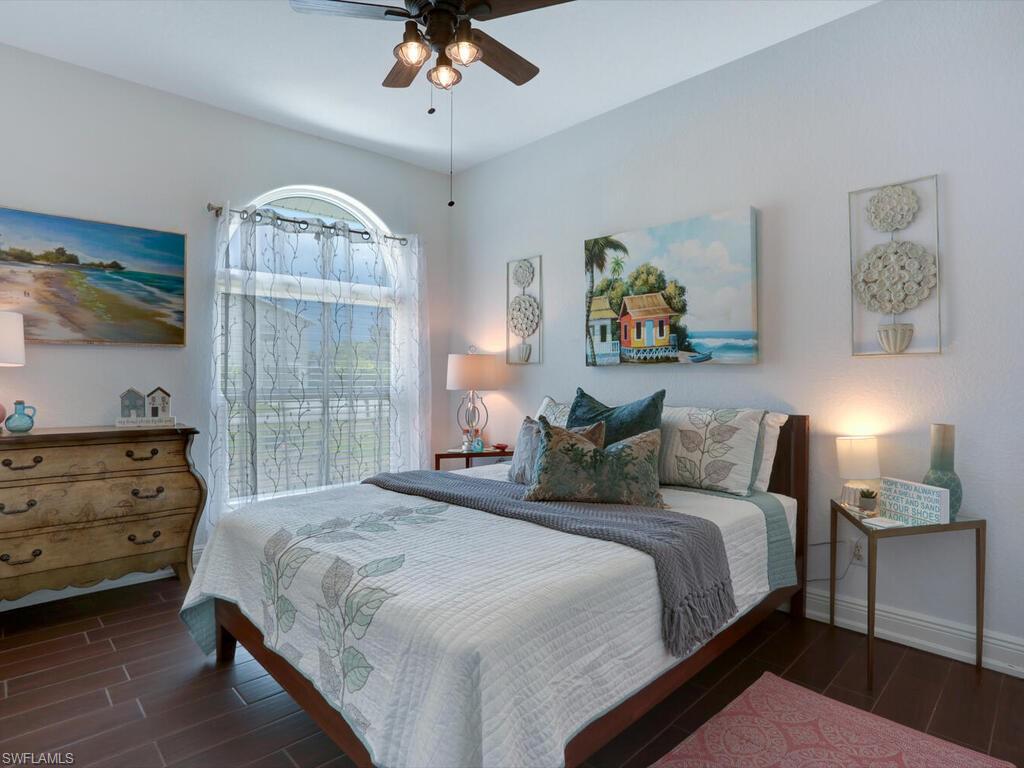 783 92nd Avenue North Naples, FL 34108 - Photo 30 of 32 a bedroom with a bed and a chandelier