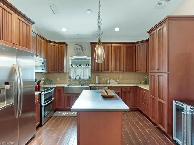 a kitchen with a sink a counter top space stainless steel appliances and cabinets