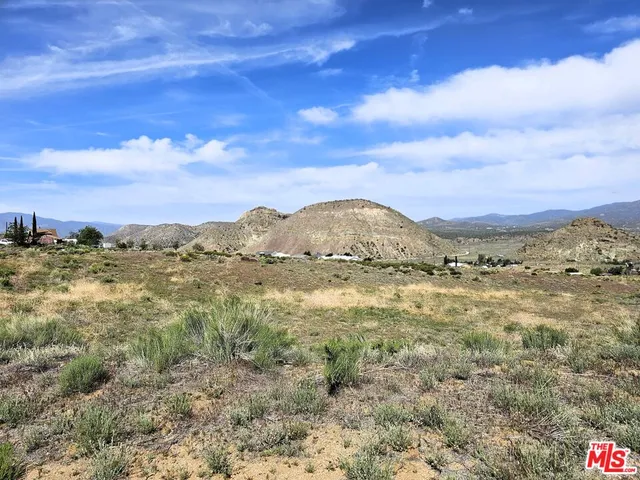 a view of a large mountain with mountains in the background