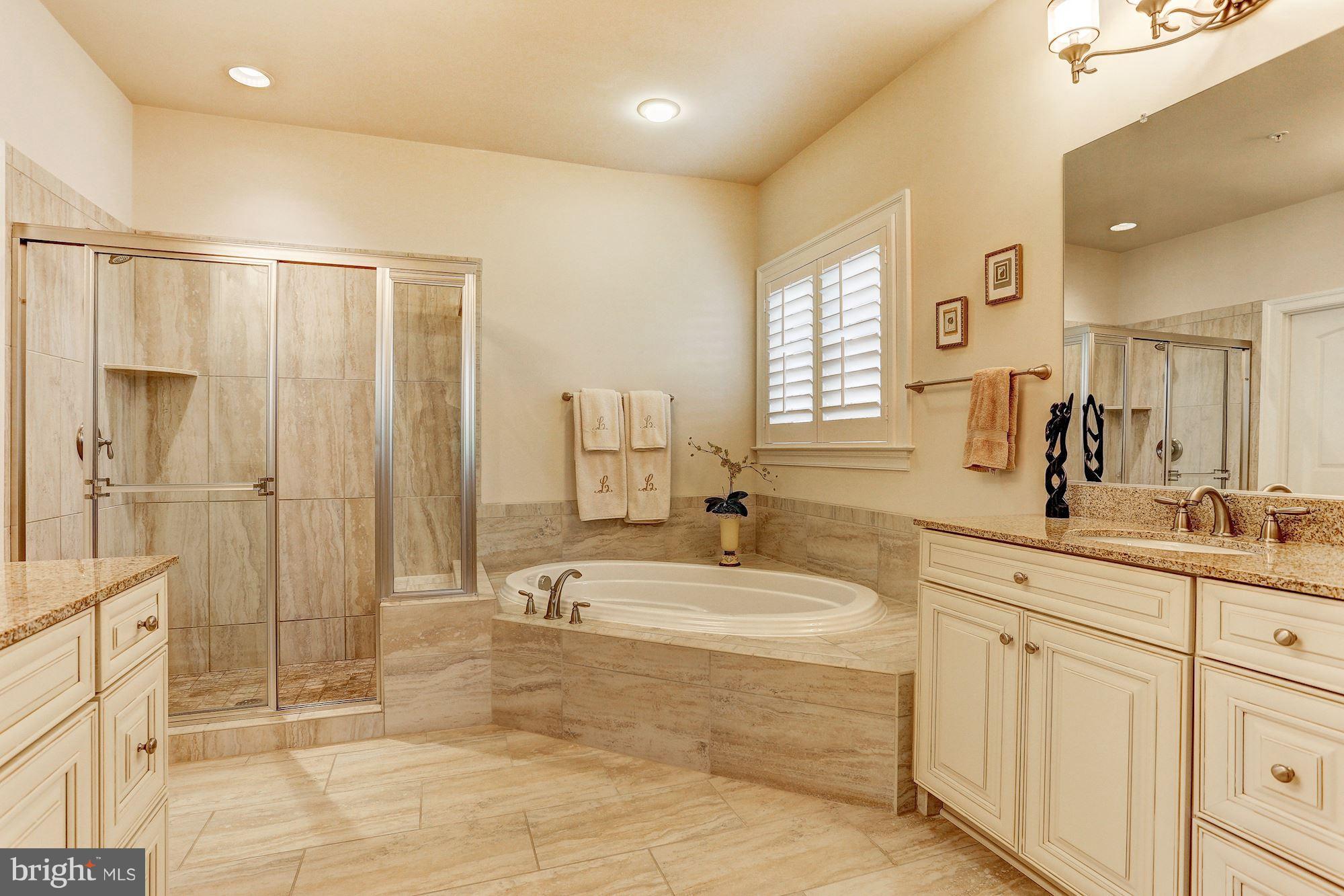 7806 Blue Ribbon Street Fulton, MD 20759 - Photo 15 of 30 a spacious bathroom with a double vanity sink a mirror and a shower