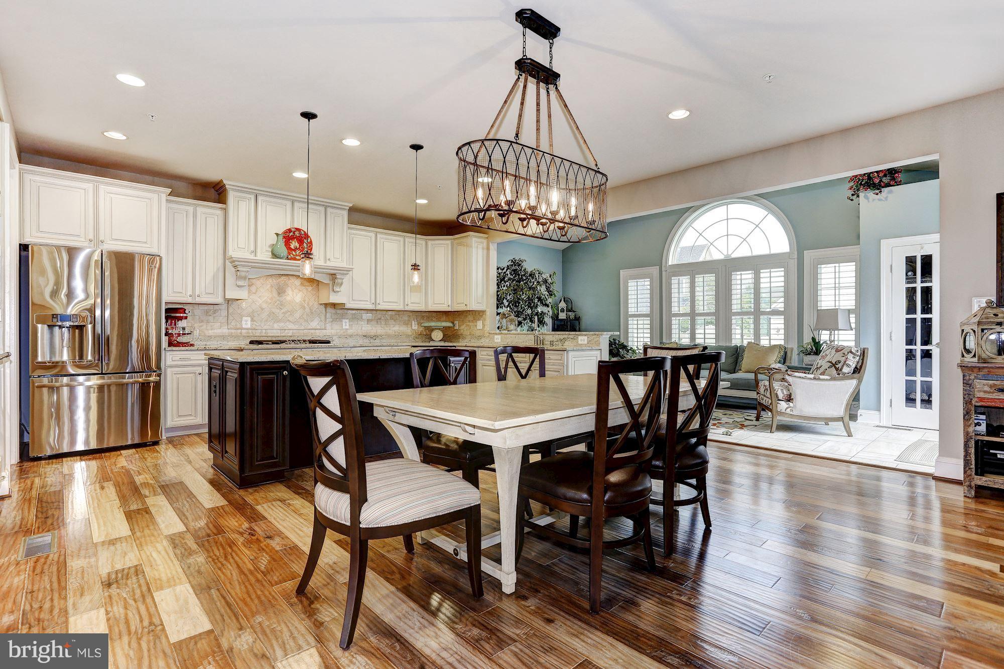 7806 Blue Ribbon Street Fulton, MD 20759 - Photo 5 of 30 a view of a dining room and livingroom with furniture wooden floor a chandelier