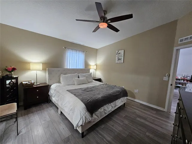 a spacious bedroom with a bed and a ceiling fan