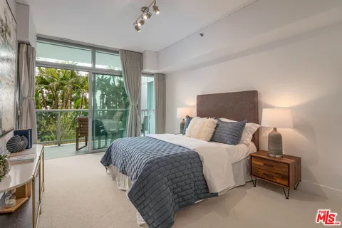 a bedroom with a bed and a large window