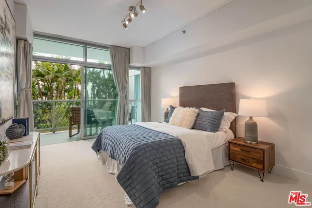 a bedroom with a bed and a large window