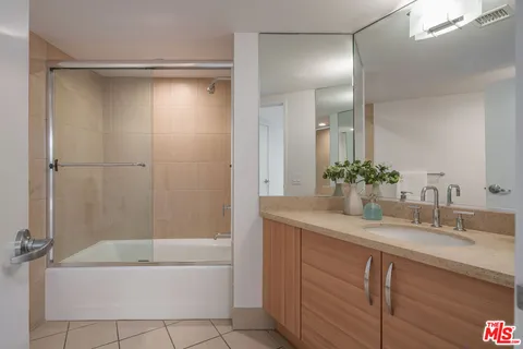 a bathroom with a tub shower vanity and a sink