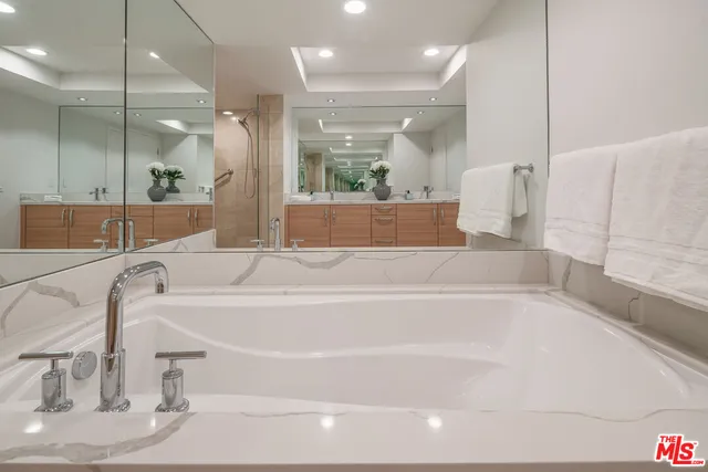 a bathroom with a bathtub and a large mirror
