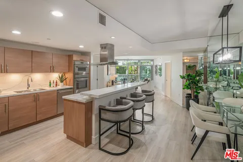 a kitchen with granite countertop kitchen island stainless steel appliances a table and chairs