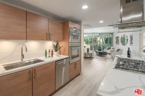 a kitchen with stainless steel appliances a sink a stove and a wooden floors