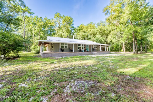 a view of a porch with wooden floor and roof with a garden view