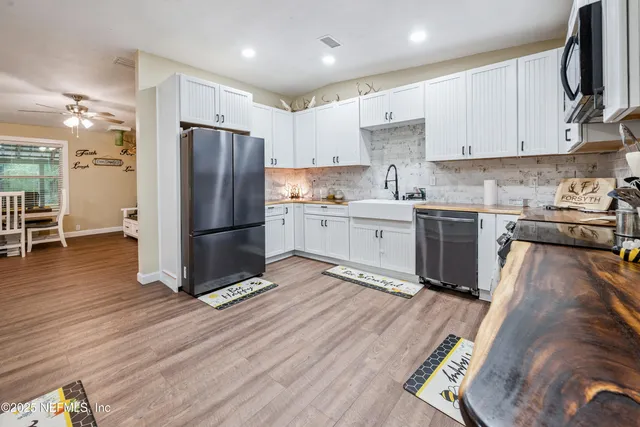 a kitchen with a refrigerator and white cabinets