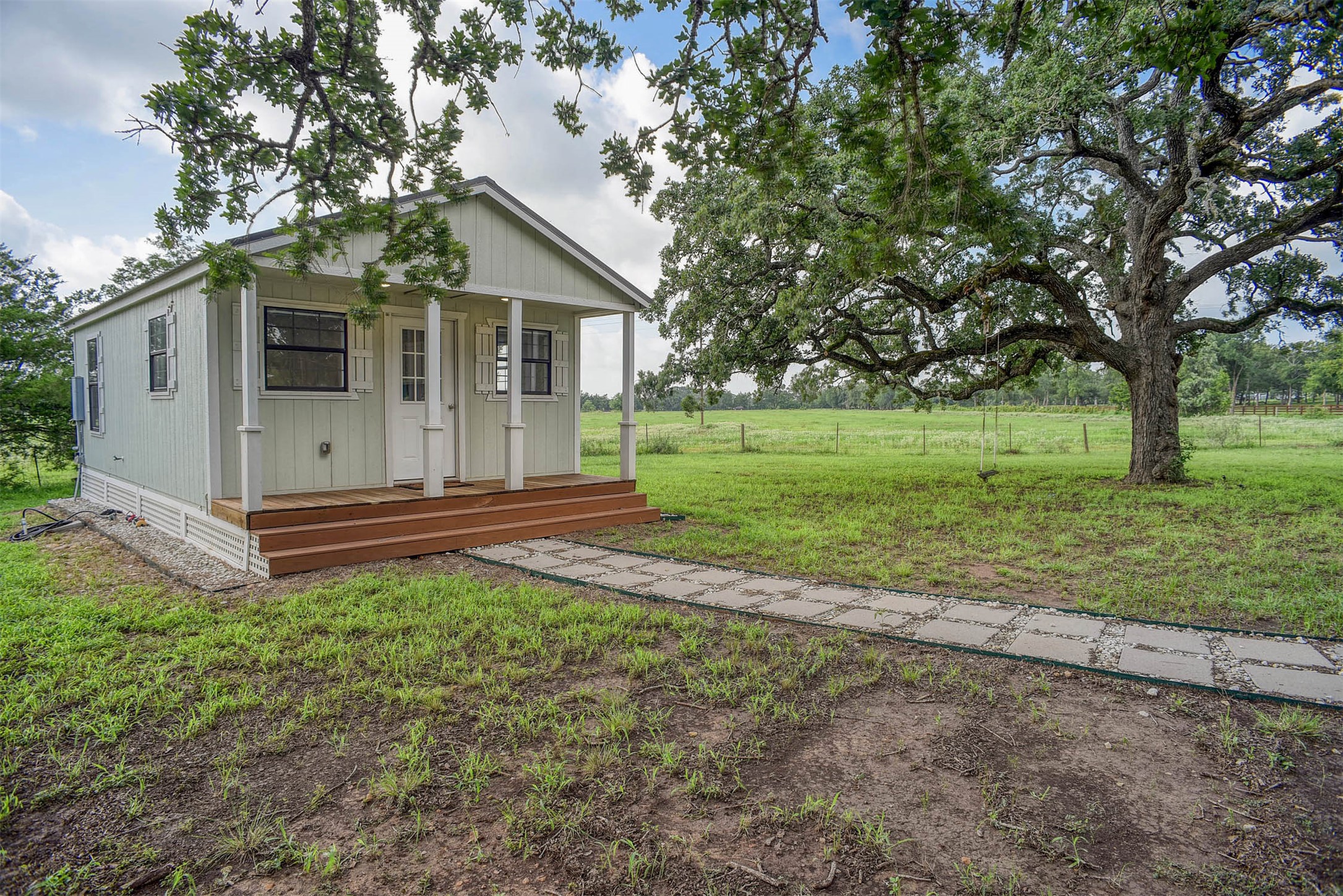 141 Grassyville Road Paige, TX 78659 - Photo 34 of 34 a view of a house with yard and a tree