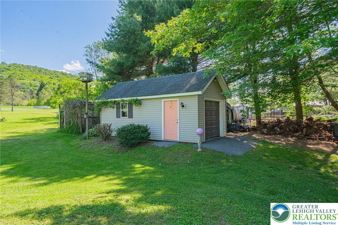 341 Lower Greenhill Road Kunkletown, PA 18058 - Photo 64 of 69 A detached garage with an inviting pink door stands ready for projects or storage.