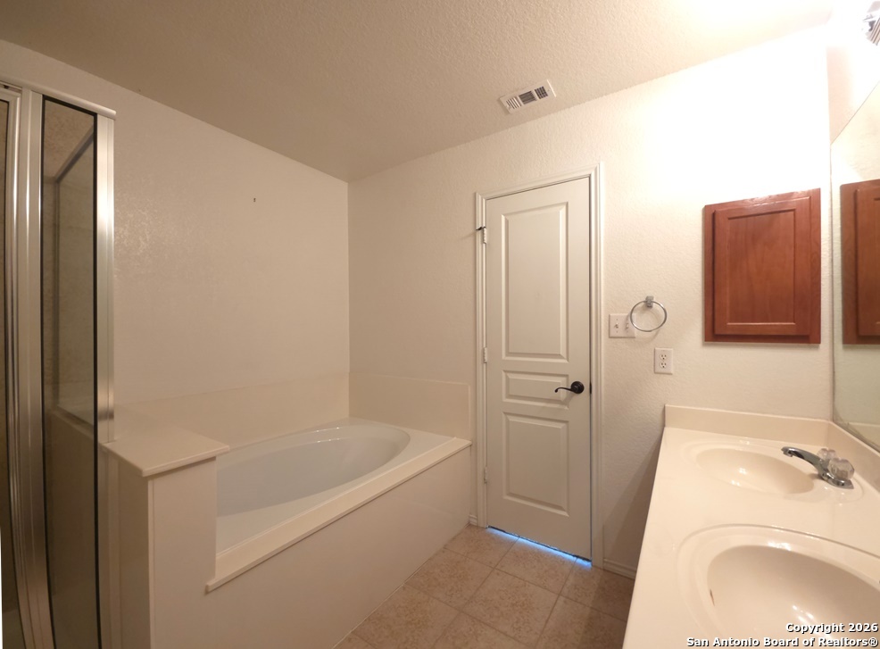 3907 Paradiso Loop San Antonio, TX 78260 - Photo 18 of 30 a bathroom with a tub sink and mirror