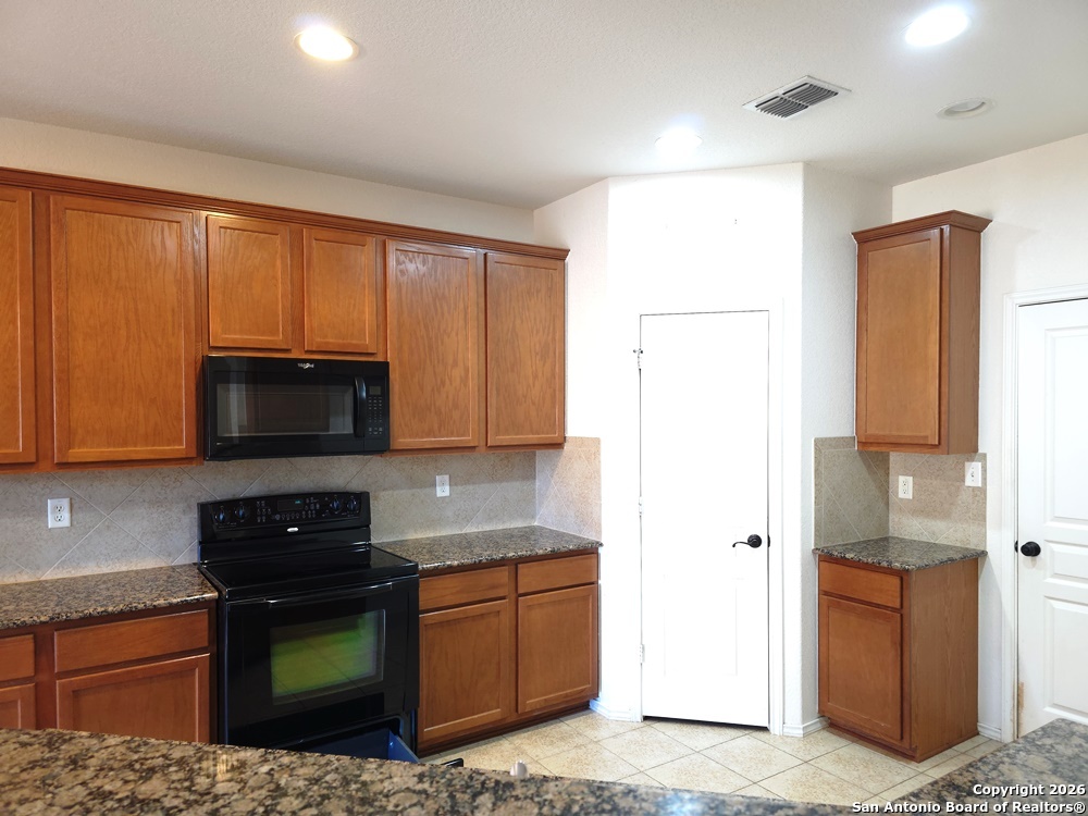 3907 Paradiso Loop San Antonio, TX 78260 - Photo 9 of 30 a kitchen with stainless steel appliances granite countertop a refrigerator a stove top oven a sink and dishwasher