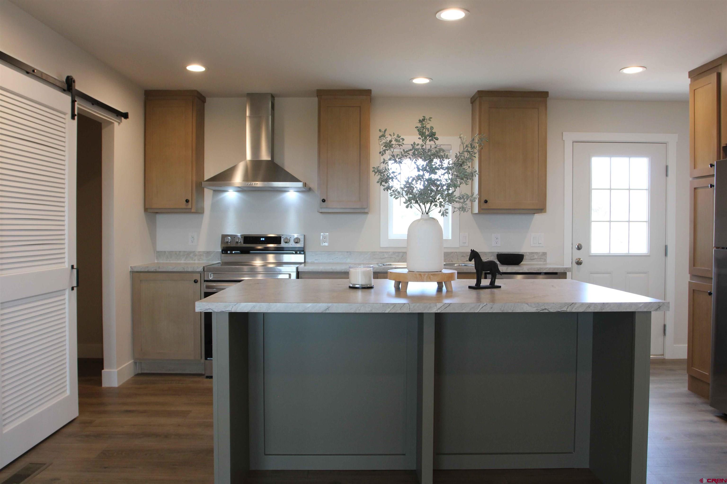 29173 P 50 Road Hotchkiss, CO 81419 - Photo 16 of 38 a kitchen with stainless steel appliances granite countertop a sink a stove a refrigerator and island with wooden floor