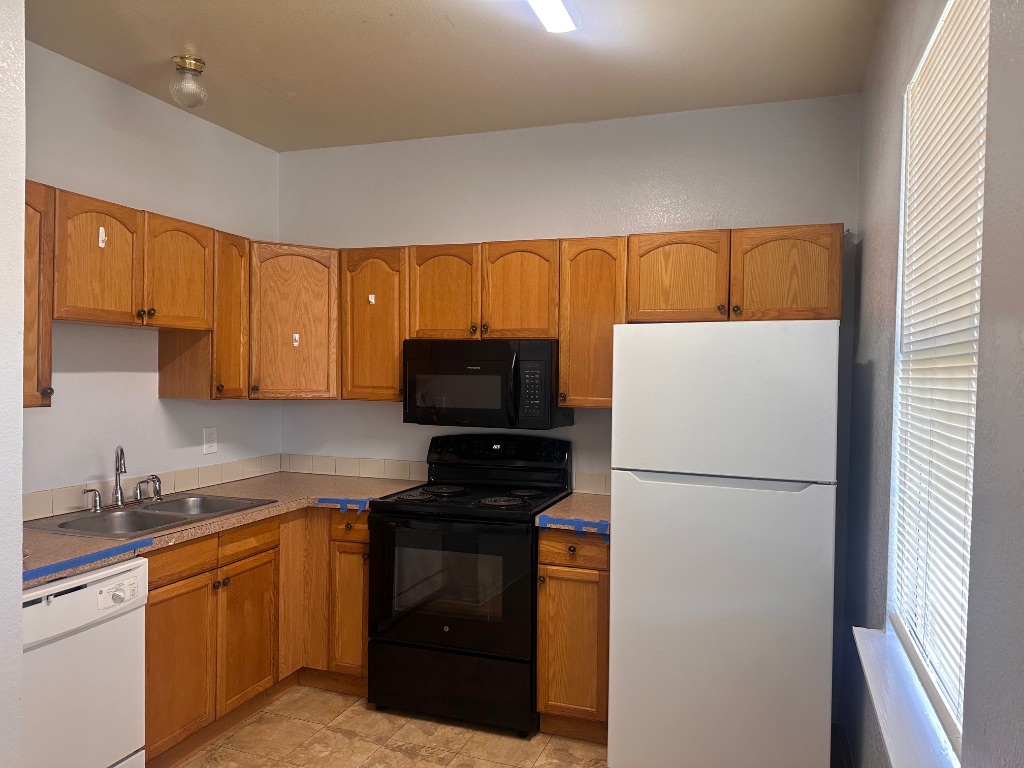251 Zimmerman Avenue, Unit A Bastrop, TX 78602 - Photo 4 of 8 a kitchen with a refrigerator sink and cabinets
