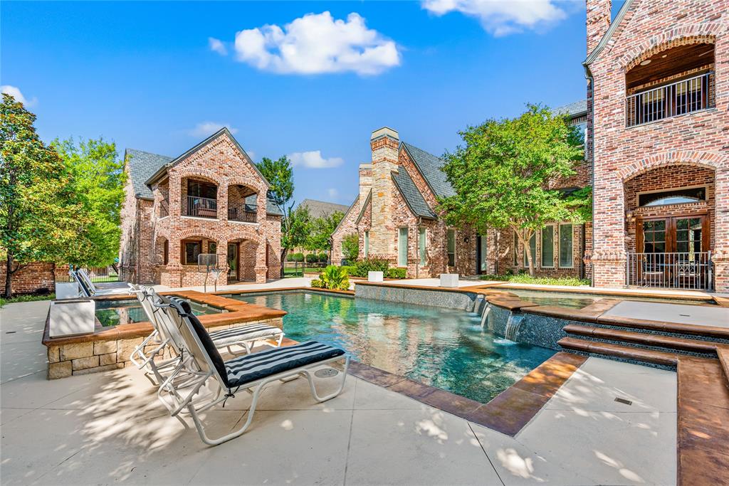 6900 Rockingham Court Colleyville, TX 76034 - Photo 30 of 40 Outdoor heated swimming pool with integrated spa and water, and fire features, surrounded by light-colored hardscaping.